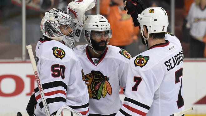 Chicago Blackhawks goalie Corey Crawford (50), defenseman Johnny Oduya (27) and defenseman Brent Seabrook (7) celebrate the 5-2 victory against the Anaheim Ducks in Game 7 of the Western Conference final.