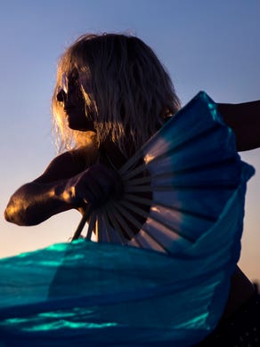 A woman dances with fans during the community drum circle at Siesta Key Beach on Sunday, January 21, 2018 in Sarasota. 