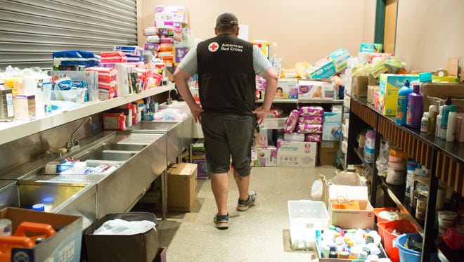 This Advertiser file photo shows a volunteer looking over supplies at the Red Cross shelter at the Heymann Center in Lafayette.