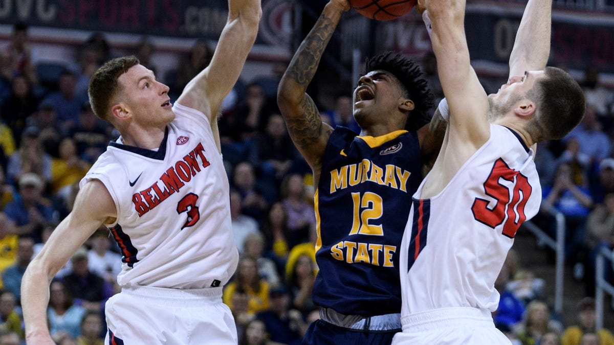 Belmont's Dylan Windler (3) and Belmont's Seth Adelsperger (50) defend against Murray State's Ja Morant (12) as he goes up for a shot during the second half of an NCAA college basketball game for the Ohio Valley Conference men's tournament championship in Evansville, Ind., Saturday, March 9, 2019. (Sam Owens/Evansville Courier & Press via AP)