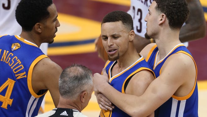 Golden State Warriors guard Stephen Curry is held back from referee Jason Phillips (23) by Shaun Livingston, left, and Klay Thompson, right, while reacting to being called for his sixth foul on Cleveland Cavaliers forward LeBron James (23) during the second half of Game 6 of basketball's NBA Finals in Cleveland, Thursday, June 16, 2016. (AP Photo/Ron Schwane)