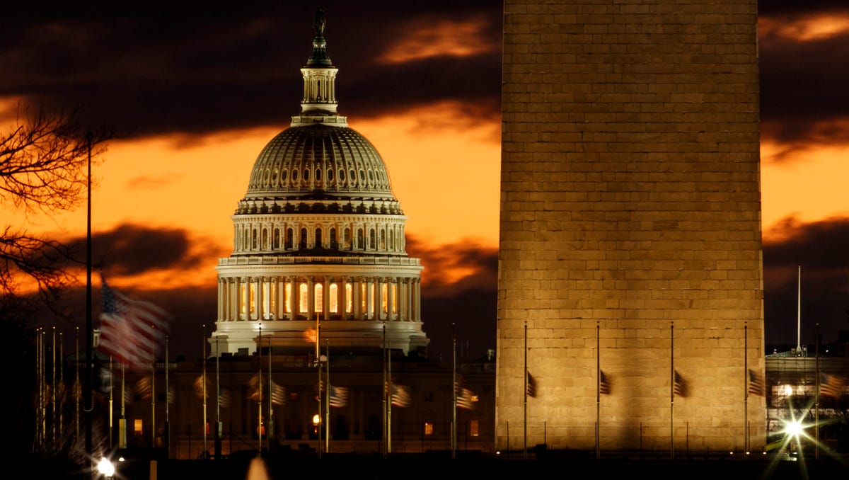 The U.S. Capitol dome is seen past the base of the Washington Monument just before sunrise in Washington. Hundreds of thousands of federal workers faced a partial government shutdown early Saturday after Democrats refused to meet President Donald Trump's demands for $5 billion to start erecting a border wall with Mexico.