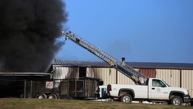 A firefighter works on a ladder truck to put out the fire at the Chester County Solid Waste & Recycling Department in Henderson, Tenn., on Wednesday, Oct. 5, 2016.