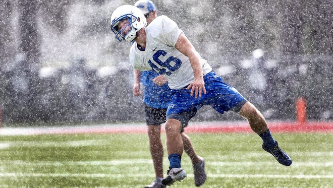 University of Memphis kicker Jake Elliott kicks off in a downpour.