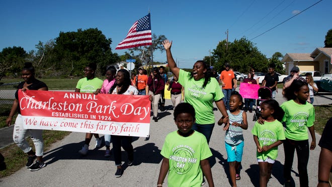 LaShay Russ, center, the resident coordinator for the Charleston Park community leads residents and supporters during a parade around the community on Charleston Park Day on Saturday 4/28/2018.  
