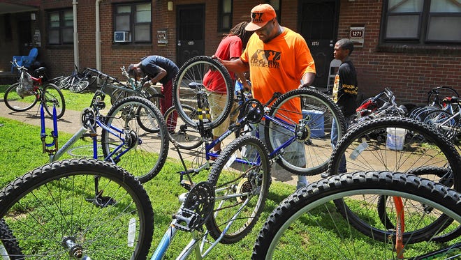 Terry Key, founder of the Edgehill Bike Club, along with others, work on bikes that will eventually be given free to kids in the neighborhood. Vanderbilt recently donated 31 bikes to the Edgehill Bike Club, where kids will repair and then use the bikes.
