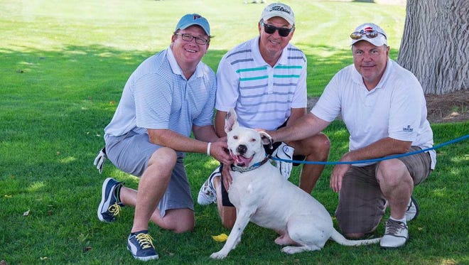 Golfers, from left, Ron Bruder, Tobe Turpen and Kyler Breen take a moment to pet
Pinto the dog at Picacho Hills Country Club at last year’s Mulligans Fore Mutts Golf Tournament
benefiting ACTion Programs for Animals.