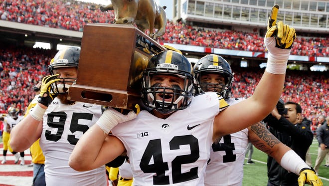 Iowa fullback Macon Plewa (42) helps carry the the Heartland Trophy with teammates Drew Ott (95) and Nate Meier after the Hawkeyes' 10-6 win at Wisconson on Oct. 3.
