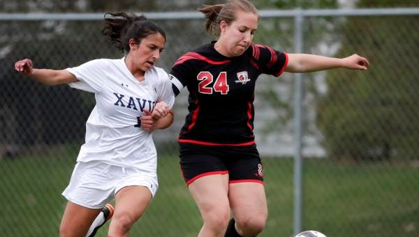 Xavier High School's Ellie Arndt fights for control of the ball with Seymour High School's Hannah Schultz Tuesday, May 8, 2018, in Appleton, Wis. Xavier defeated Seymour 4-0.