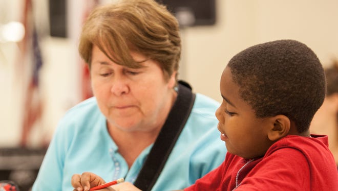 Elizabeth Crowe, who is retiring from being director of children's programs at Grace Missions. Here, she helps helps Travis Davis, , learn multiplication at an after school program run by Grace Mission Episcopal Church in the Joe Louis Housing Complex in 2013.