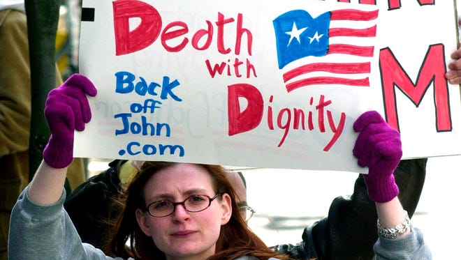 In this March 22, 2002, photo, Stacey Richter holds a sign outside a federal courthouse in Portland, Ore., as a hearing begins to decide the fate of Oregon's physician-assisted suicide law. Supporters of a terminally ill person's right to take his or her own life are alarmed by President Donald Trump's nominee for the vacant U.S. Supreme Court seat. They fear Neil Gorsuch could quash a growing right-to-die movement that has made gains in recent years.