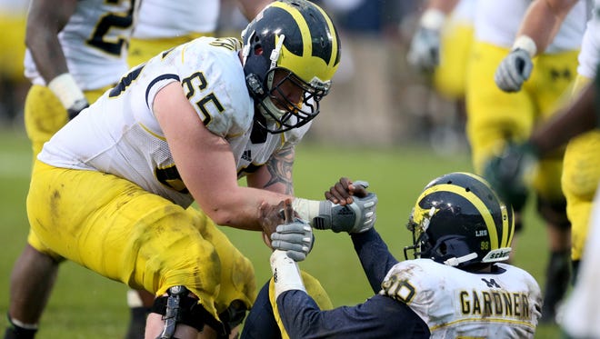 Michigan offensive lineman Kyle Bosch helps up quarterback Devin Gardner in this Nov. 2, 2013 file photo. Bosch will transfer from U-M, according to a report.