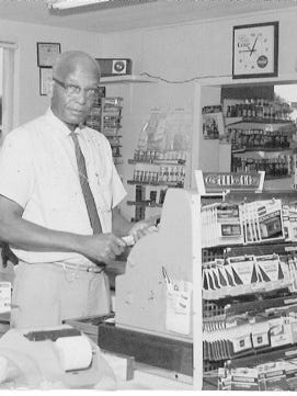 In this historic photo, Ross Evans stands behind the cash register at Evans Grocery on Florida Avenue.