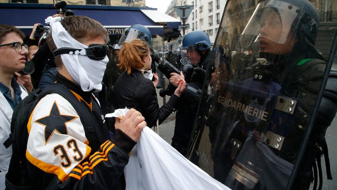 High school students face riot police officers during a demonstration in Paris on May 5, 2017.