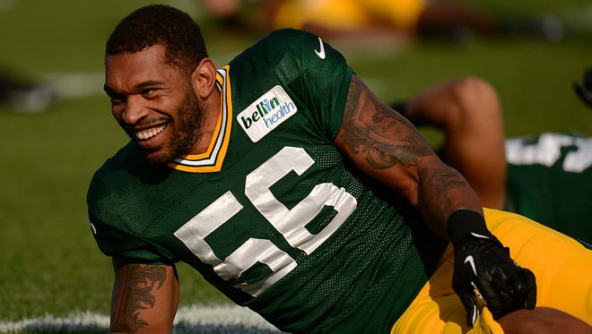 Green Bay Packers' Julius Peppers shares a smile as he stretches with his teammates during training camp practice at Ray Nitschke Field.