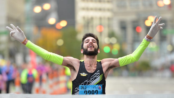 Zachary Ornelas, 24, of Ann Arbor crosses the finish line in first place Sunday in the Detroit International Marathon.