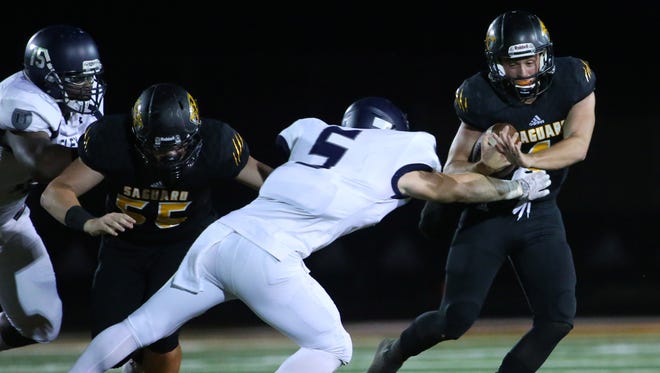 Higley's Cade Matthews (5) tackles Saguaro's Max Massingale (4) during the first half at Saguaro High School in Scottsdale, Ariz. on Sept 8, 2017.