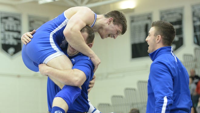 Williamstown's Bryan Martin jumps into coach Jon Jernegan's arms after his 6-3 win over Delsea's Tommy Maxwell in the 195-pound Region 8 final at Egg Harbor Township High School on Saturday.
