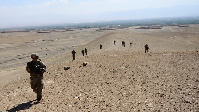 U.S. soldiers operating under the International Security Assistance Force (ISAF)  walk on the side of a hill during a patrol in Afghanistan's Logar province in 2012.