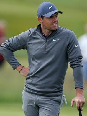 Rory McIlroy waits for his group to finish putting