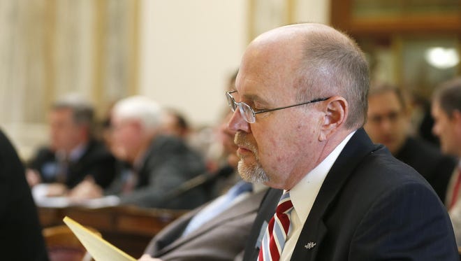Rep. Art Wittich, R-Bozeman, works from his desk on the House floor during the 64th Legislature.