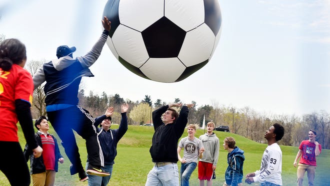 Penn State York sophomore Papakojo Kuranchie, third from left, blocks an inflatable 6-foot soccer ball bumped airborne by sophomore Jake Lauer, center. The oversized soccer game was part of Penn State York's 18th annual Unity Week to celebrate diversity and promote the campus's multicultural environment.