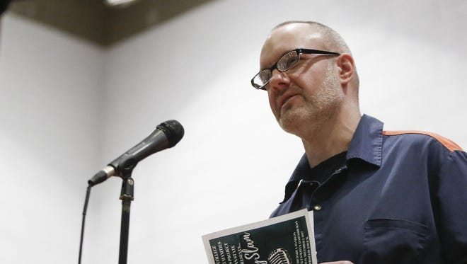 Inmate Michael Duthler reads a poem at the Richard A. Handlon Correctional Facility.