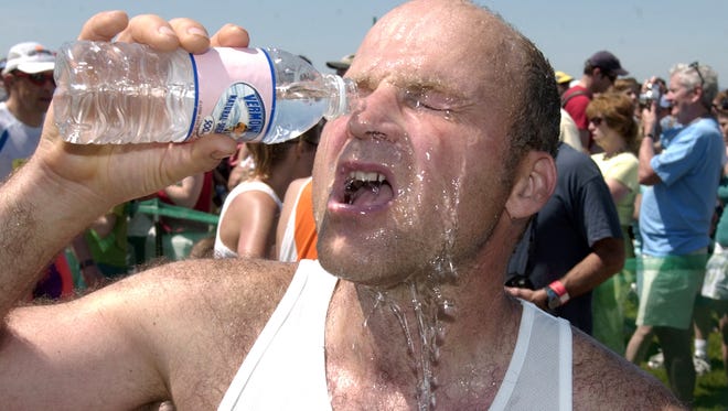 A marathon runner douses himself in bottled water at the finish line during the Vermont City Marathon in 2006, when warm weather made the race grueling. Race organizers are warning again of warm conditions this year