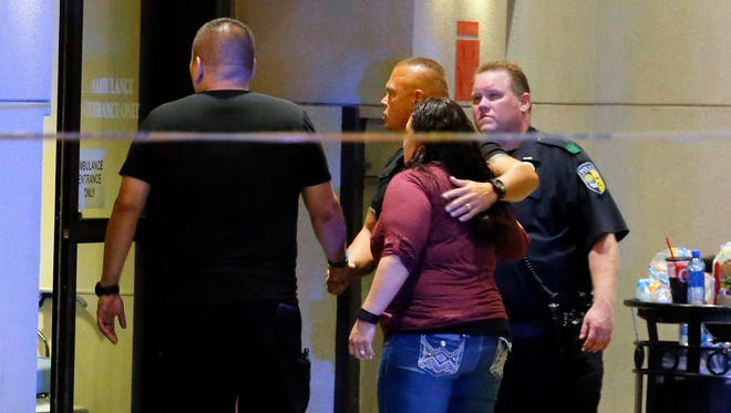 Law enforcement officials escort a couple in through the emergency room entrance at Baylor University Medical Center, Friday, July 8, 2016, in Dallas. Snipers opened fire on police officers in the heart of Dallas on Thursday night, killing some of the officers.