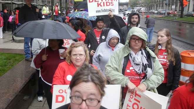 After declaring a school district wide sickout the Detroit Public School teachers take to the streets  in front of the Fisher Building on Monday. On Sunday, teachers learned that the district would not be able to pay teachers who are slated to be paid through the summer.