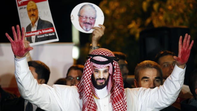 An activist wearing a mask depicting Saudi Crown Prince Mohammed bin Salman, holds up his hands painted with fake blood during a candlelight vigil for Saudi journalist Jamal Khashoggi outside Saudi Arabia's consulate in Istanbul, Oct. 25, 2018.