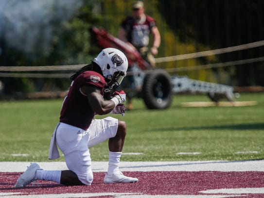 Deion Holliman kneels down after scoring a touchdown