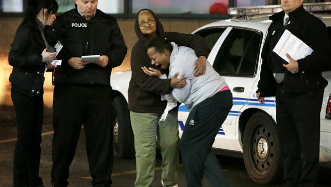 Toni Martin, front center, cries out on Wednesday, Dec. 24, 2014, as she talks to police at the scene where she says her son was fatally shot Tuesday at a gas station in Berkeley, Mo. Authorities did not immediately identify the man who was shot. But the St. Louis Post-Dispatch reported that Toni Martin, said he was her son, Antonio Martin. (AP Photo/St. Louis Post-Dispatch, David Carson)
