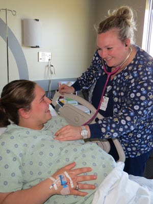 Bryn Anderson, right, a first-year obstetrics nurse resident at Spencer Hospital, cares for a patient in labor.