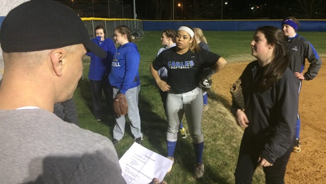 Jackson Christian softball players listen to Lady Eagles assistant coach Chad Shelton give the rundown for the first practice of 2017 at their midnight madness early Monday morning.