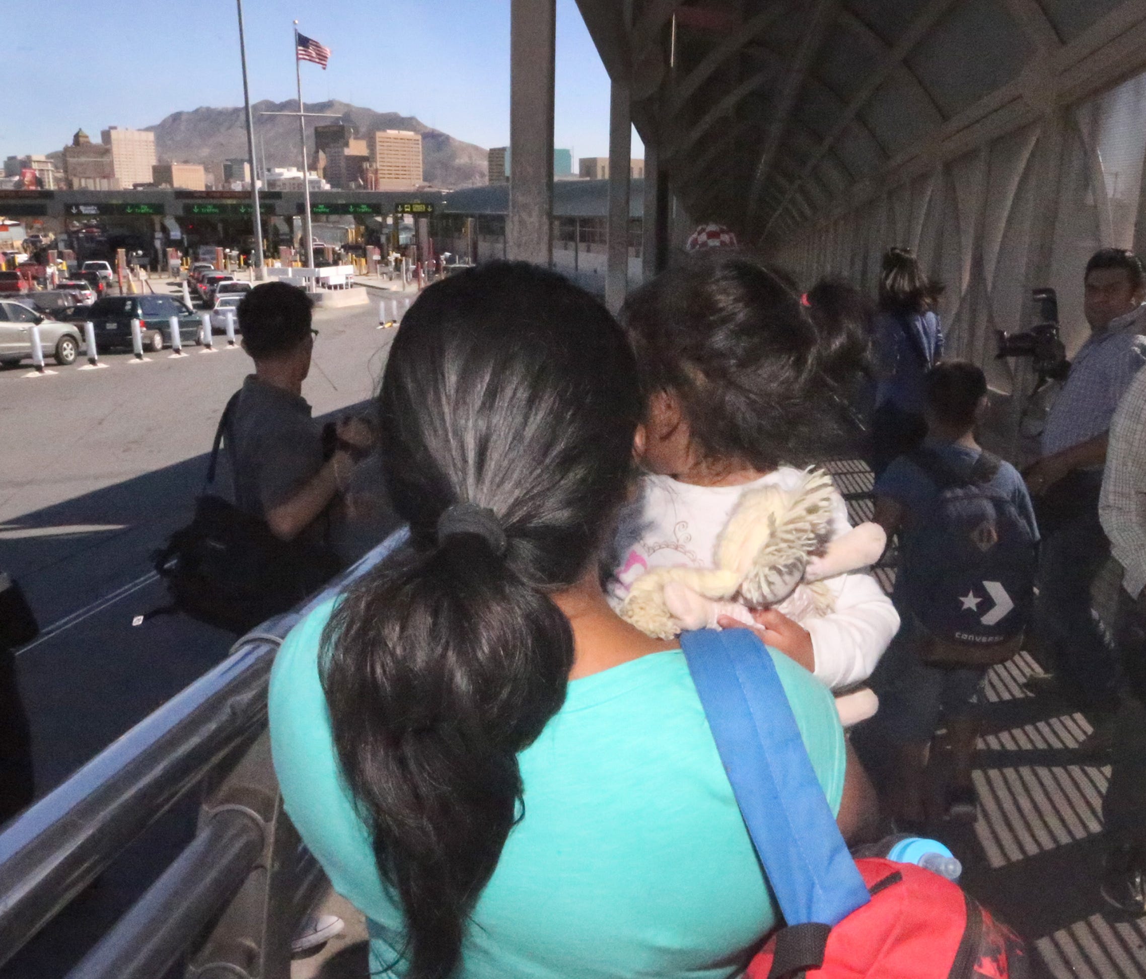 An asylum seeker from Mexico is led to the U.S. Paso Del Norte Port of Entry in El Paso with a small child in tow Wednesday. U.S. Customs and Border Protection officials led two women and their children, who were seeking asylum into the port facility