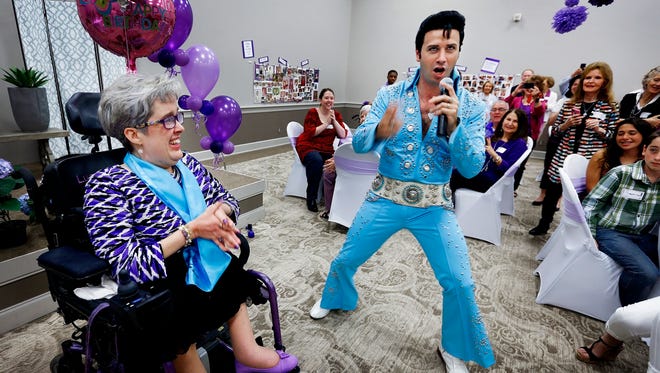 Longtime Graceland employee and spina bifida patient Beth Dixon, (left) celebrates her 50th birthday with a serenaded from Elvis tribute artist Brain Lee Howell (right) during a party at First Evangelical Church, Saturday afternoon.