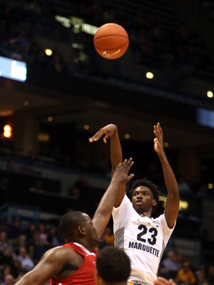 Marquette Golden Eagles guard Jajuan Johnson (23) attempts a basket over Fresno State Bulldogs center Terrell Carter II (left) at the BMO Harris Bradley Center. Marquette defeated Fresno State, 84-81.
