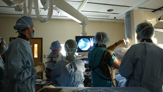 A fluoroscope like the one in this image (the white arm above the heads of the medical team) is at the center of a lawsuit between a Salisbury doctor and a surgery center.
