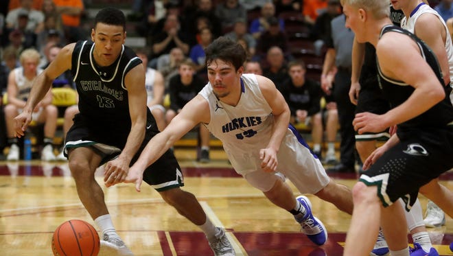 Clark/Willow Lake's Bradyn Rusher, left, and Bridgewater-Emery's Carter Dye, center, go after a loose ball during Friday night's semi-final game at the South Dakota Class B boys basketball tournament at Wachs Arena. Looking on are the Cyclone's Jacob Prouty, right and the Huskies' Sawyer Schultz, back right.