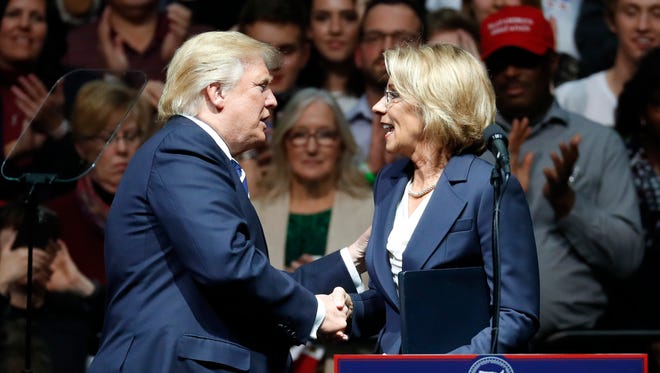 President-elect Donald Trump shakes hands with his pick for Education secretary Betsy DeVos during a December rally in Grand Rapids, Mich.