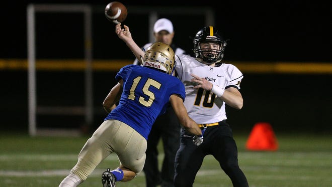 McQuaid quarterback Hunter Walsh stands in to deliver a pass over Schroeder's Mike Gutierrez. 