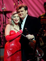 Emmylou Harris and Ricky Skaggs hug after performing