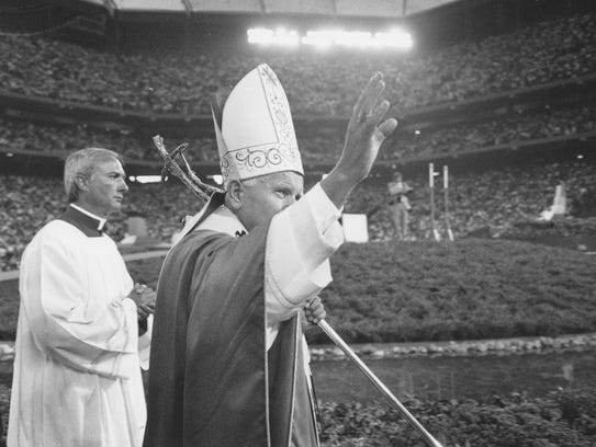 Pope John Paul II waves goodby to a crowd of 90,000