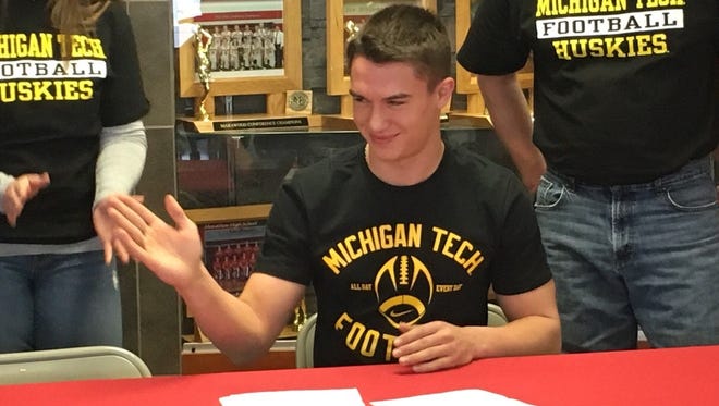 Marathon senior Donavon Free motions to his teammates and classmates after signing a national letter of intent with the Michigan Tech football program Wednesday morning.