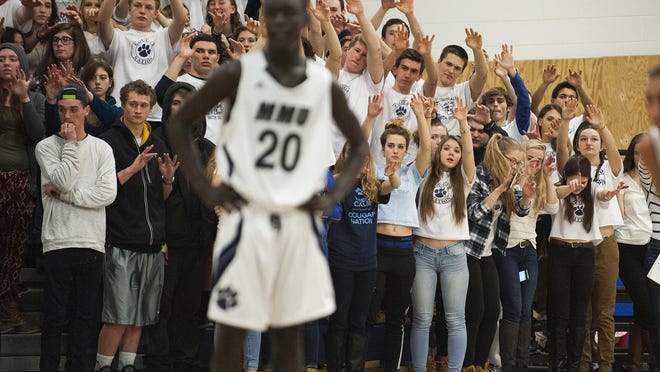 Mount Mansfield fans raise their hands during a free throw attempt during Tuesday night’s first-round high school boys basketball playoff game against Colchester in Jericho.