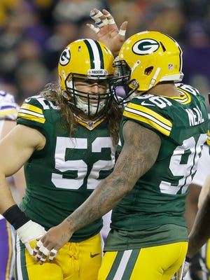 Green Bay Packers inside linebacker Clay Matthews (52) celebrates a defensive play with outside linebacker Mike Neal (96) against the Minnesota Vikings at Lambeau Field.