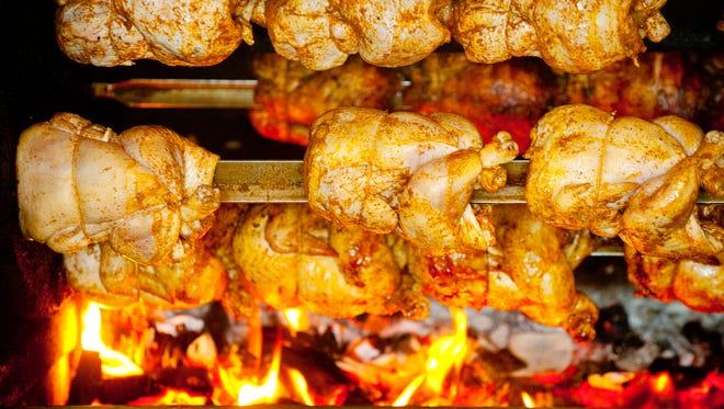 Whole chickens being roasted over the charcoal at the Yummy Pollo restaurant on Bishop Lane.April 26, 2018