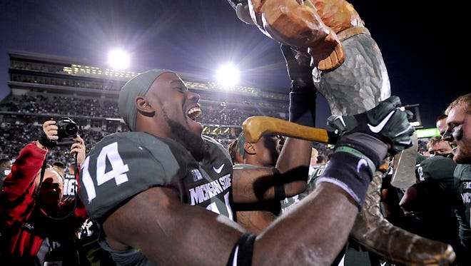MSU's Tony Lippett   screams as he holds up the Paul Bunyan Trophy after MSU's 35-11 win over Michigan   at Spartan Stadium for the big rivalry game Saturdsy 10/25/2014.  (Rod Sanford | Lansing State Journal)