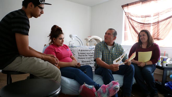Roy Urias, dad coordinator, and Leslie Fiveash, family coach - both with Healthy Families San Angelo - talk with teen parents Jacob and Angel Mendoza at their apartment Monday, Sept. 2, 2017.